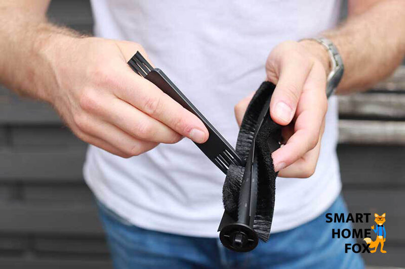 Haare werden mit Hilfe eines speziellen Reinigungswerkzeugs aus der Bürste entfernt